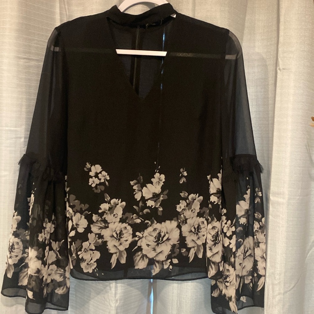 Blouse is see-through high collar, keyhole front.